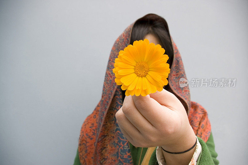 一个印度女孩拿着一朵花