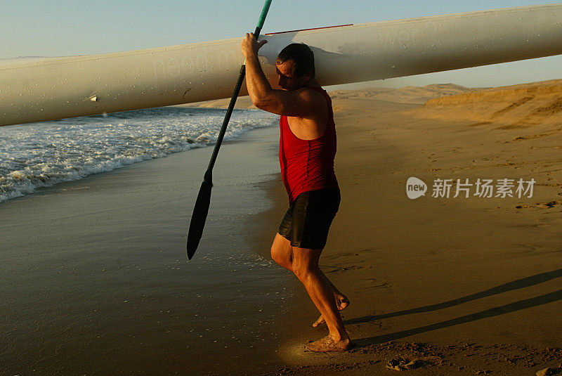 人类携带着皮划艇进入海洋