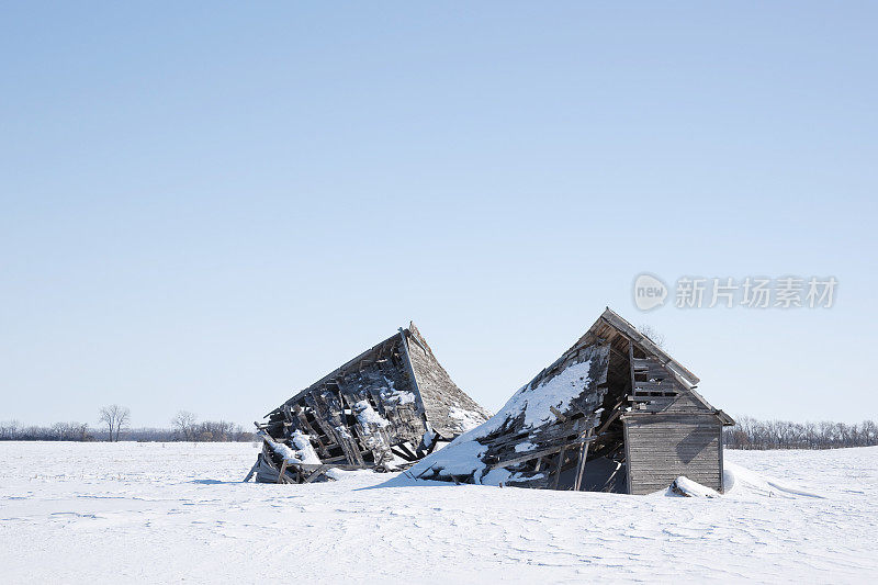 旧的，塌陷的谷仓废墟上的雪景。