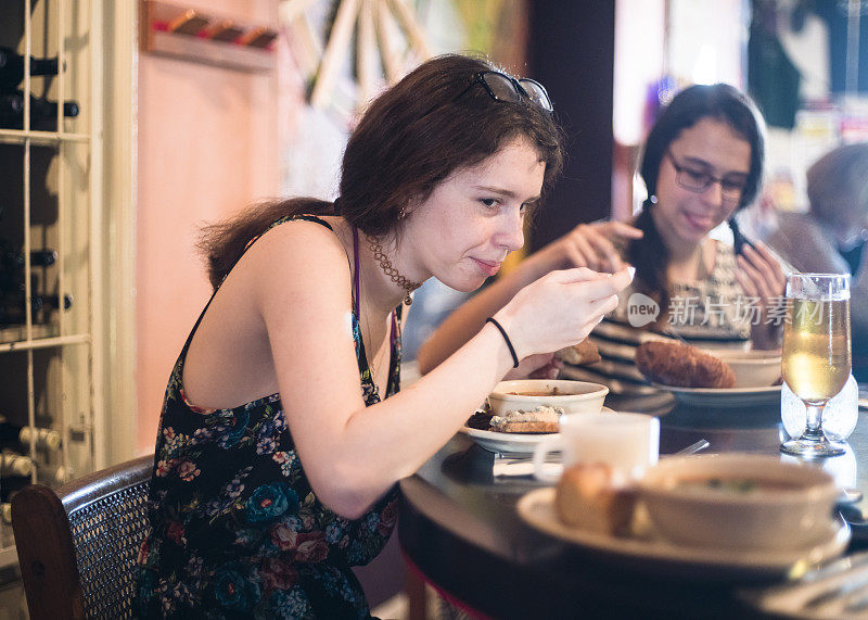 两个十几岁的女孩在咖啡馆吃饭