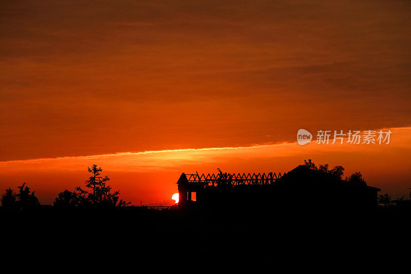 日落时，树木和建筑与天空和云彩形成剪影