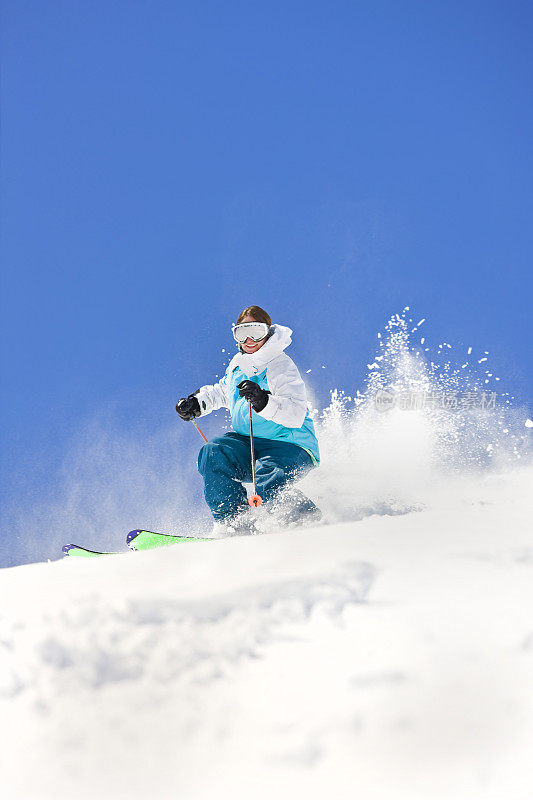 女性在科罗拉多蓝天下滑雪