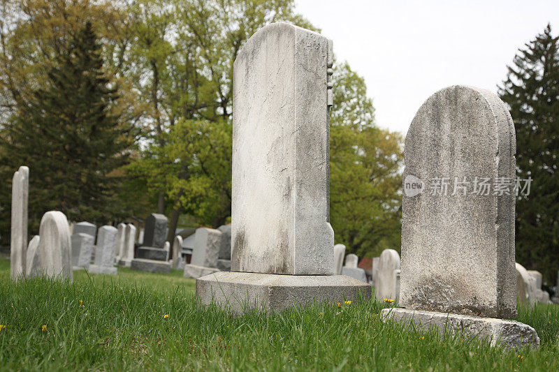 老风化的墓碑在墓地低角度观看