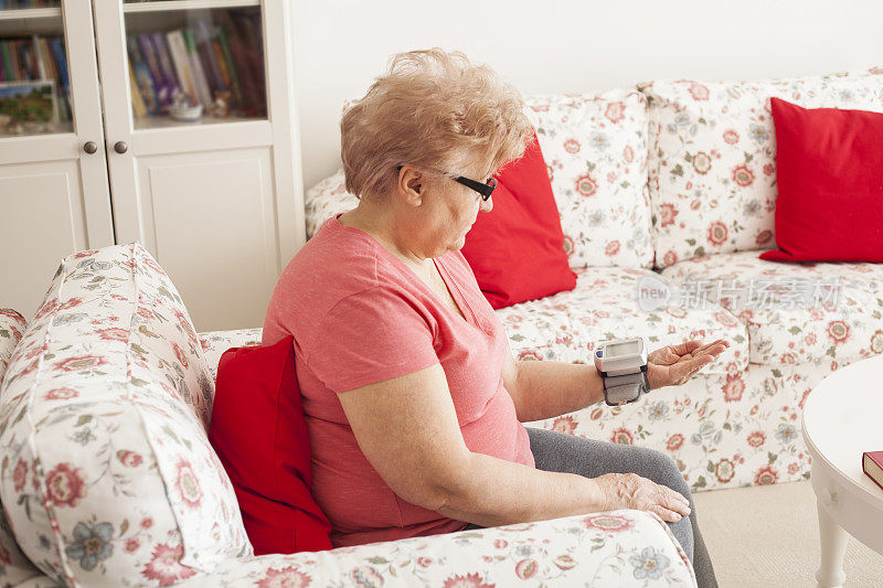 老年妇女使用自动血压计