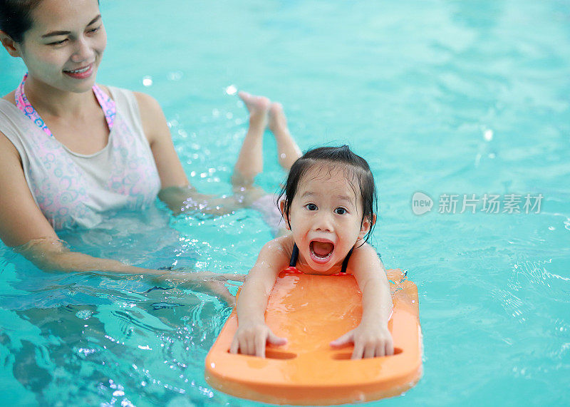 近距离的妈妈教孩子在游泳池。