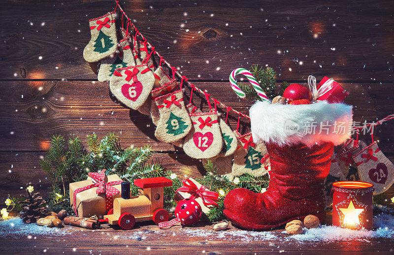 圣诞日历和圣诞老人的鞋和礼物在乡村木制背景