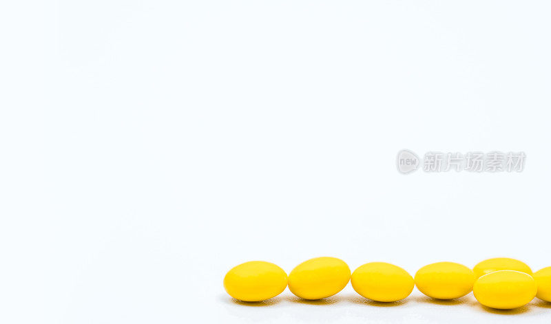 黄色糖衣片剂药丸，白色背景与拷贝空间。治疗便秘的药物。