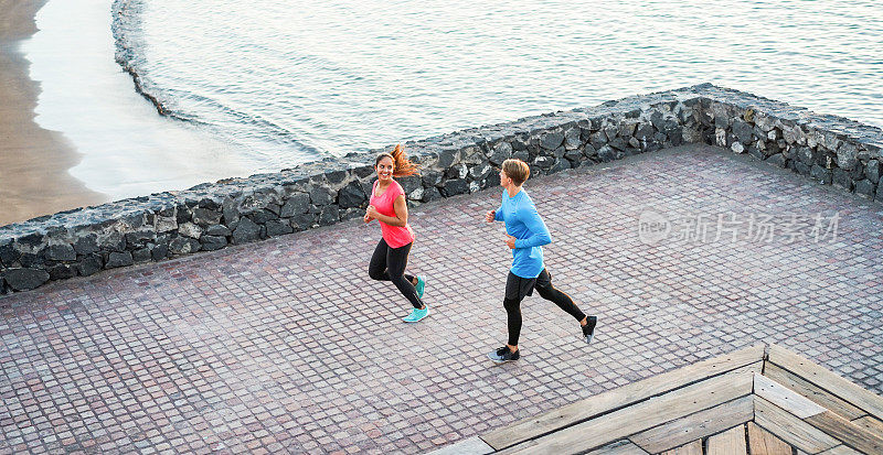 健身年轻夫妇户外跑步与海洋背景-运动快乐的人在热带地方训练-健康的生活方式，幸福，慢跑和活力的概念-未经过滤的照片