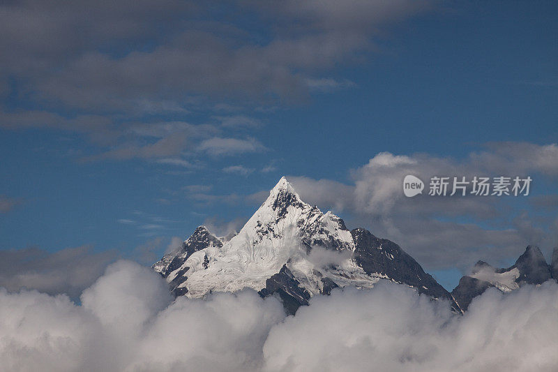 中国云南梅里雪山景观，小村庄以雪山为背景的清晨。