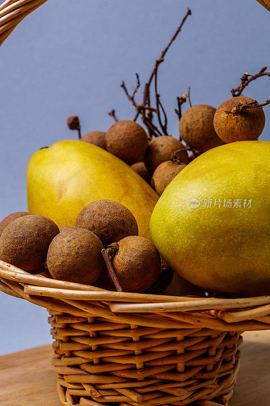 新鲜的泰国水果装在篮子里放在木桌上。