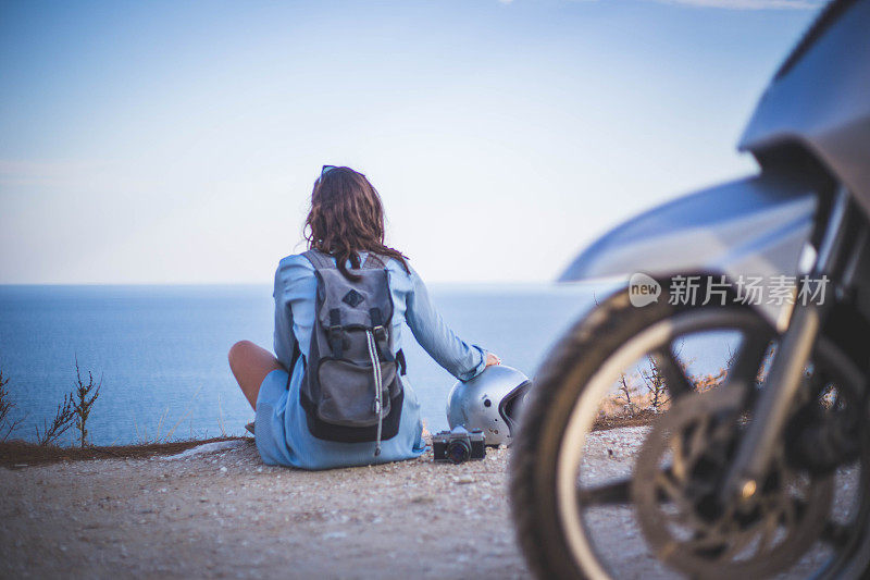 女孩骑着摩托车欣赏海景