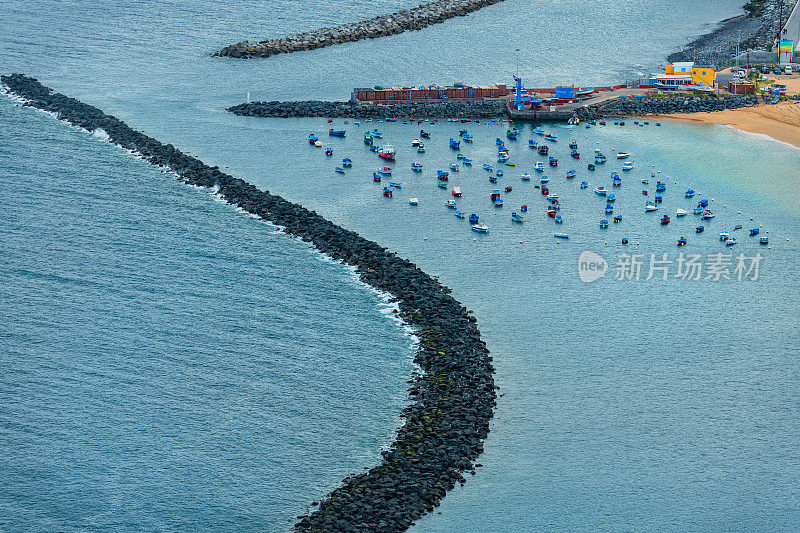 石头盾牌抵御海浪，沙滩和棕榈树在加那利岛靠近，特内里费，西班牙
