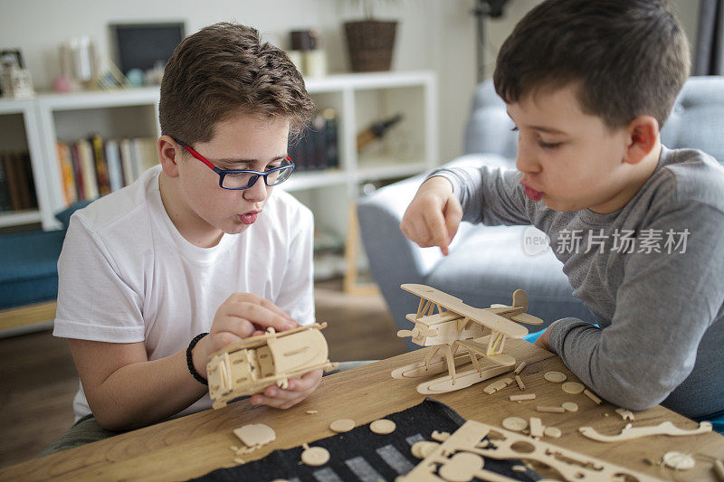 兄弟们正在为学校项目制作木制模型飞机