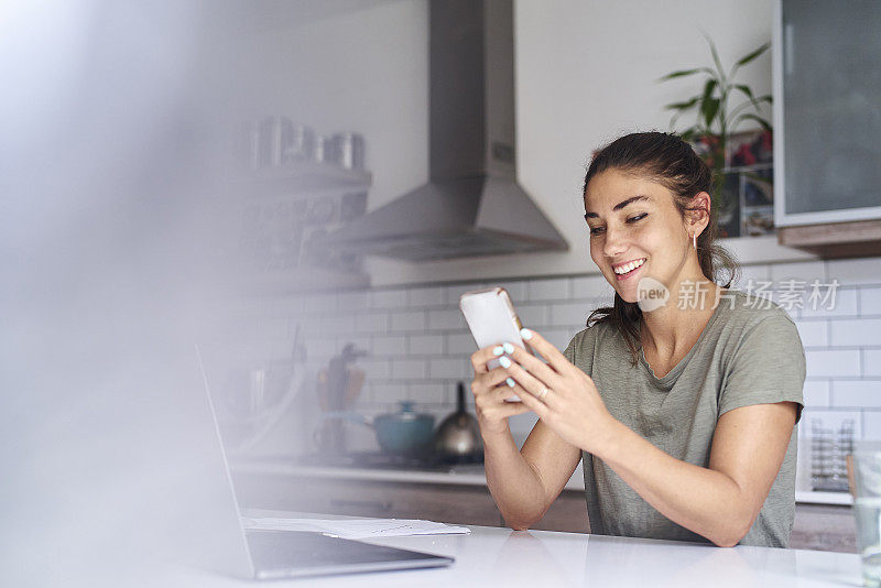 年轻的成年西班牙女人用智能手机发短信