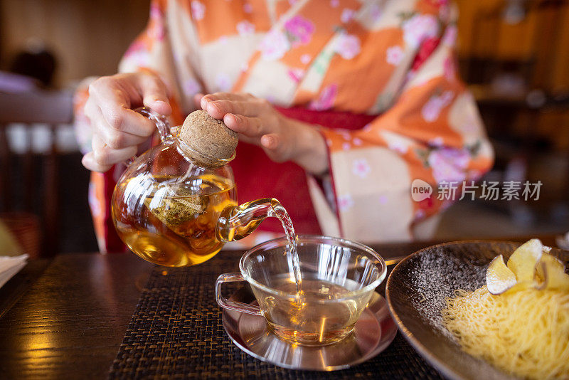 穿着和服的女人在咖啡馆倒茶