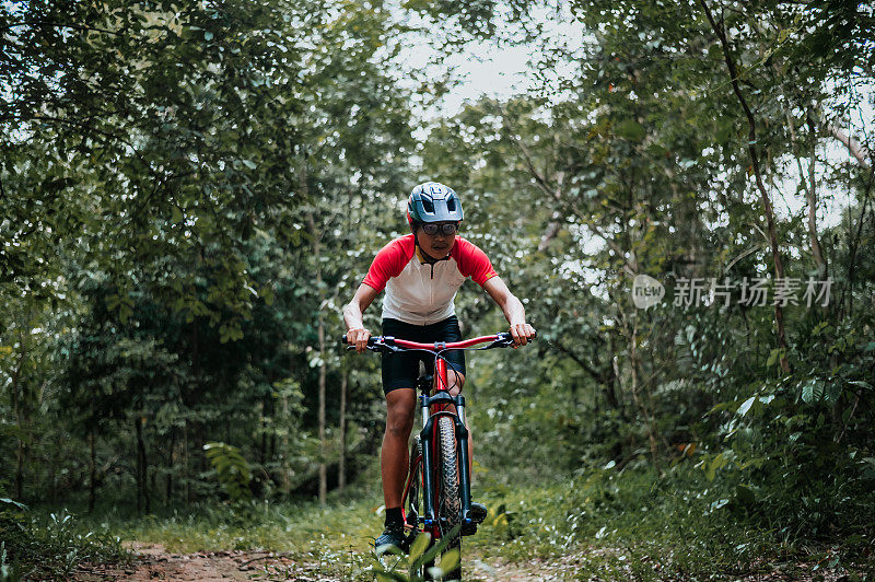 山地车骑行MTB，山地车下坡到达极限。一名亚洲男子骑着山地车在野外极限下坡。极限运动和MTB，山地自行车下坡概念。