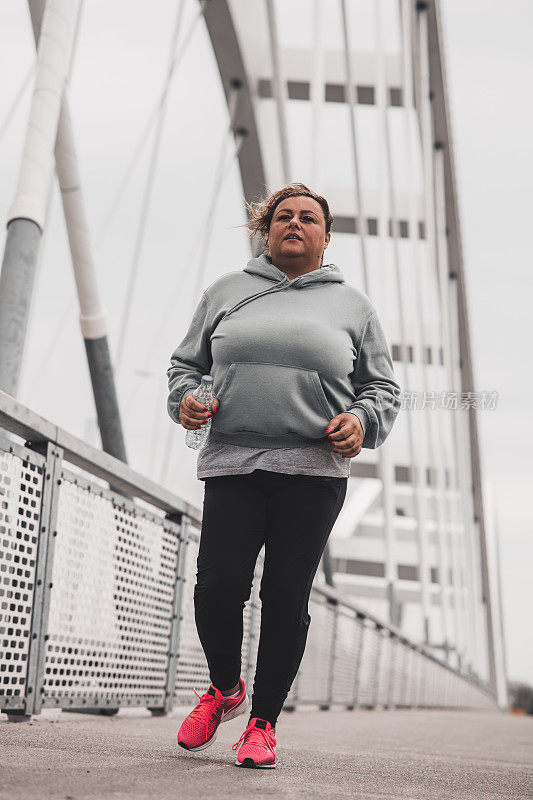 大号拉丁女人在桥上慢跑