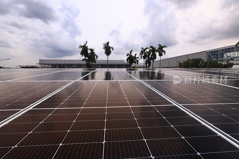 安装在建筑物屋顶上的蓝色光伏太阳能电池板，在日落时产生清洁的生态电力。生产可再生能源的理念。