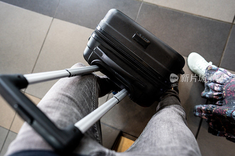一个人在机场提着行李箱走着的高视角