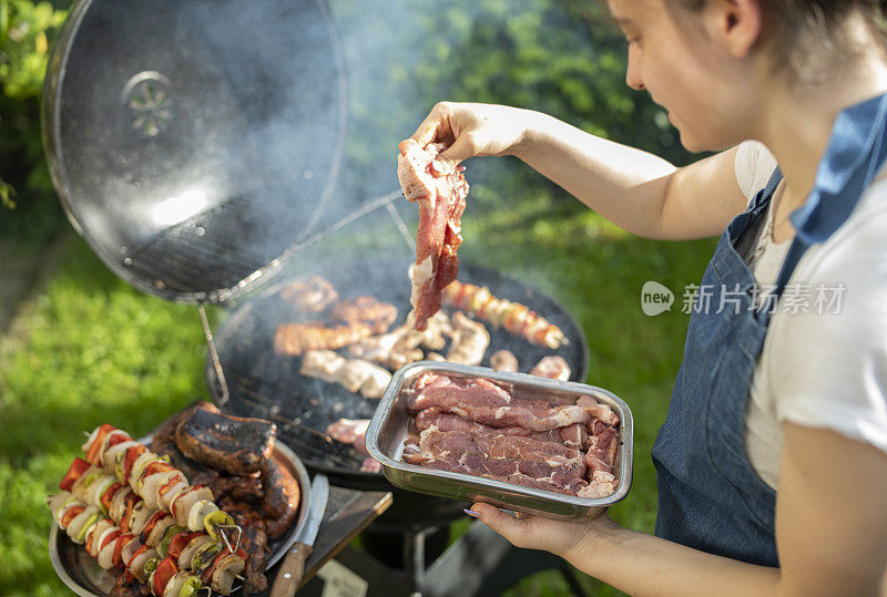 年轻女子正在为家人准备烤肉。