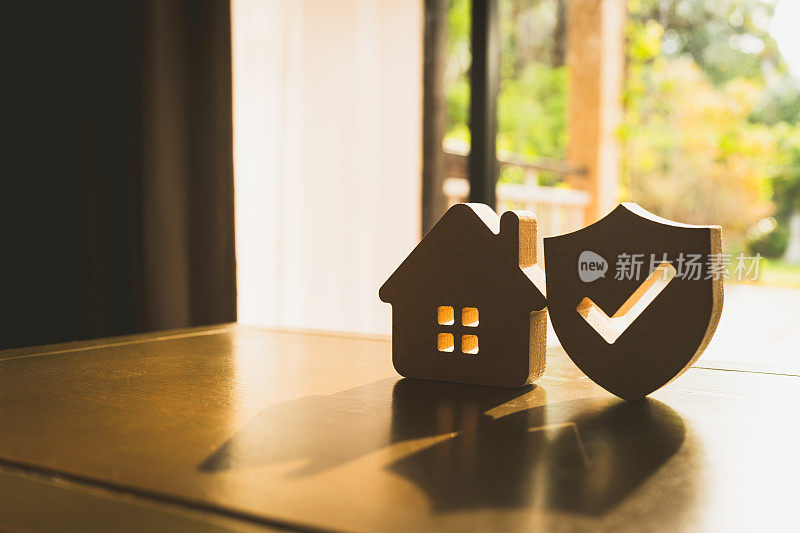 木屋模型和房地产保险构思，还有小盾图标。房屋灭失和火灾保险，建筑火灾保险概念。