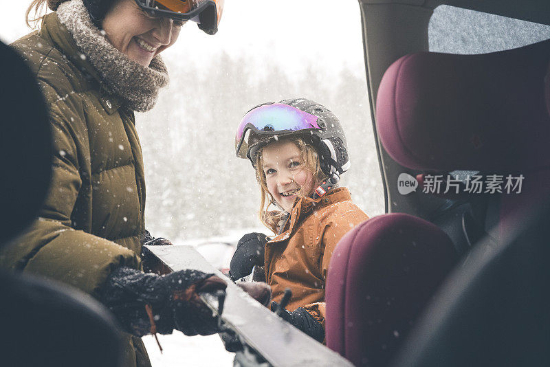 母亲和女儿正在打开汽车准备滑雪