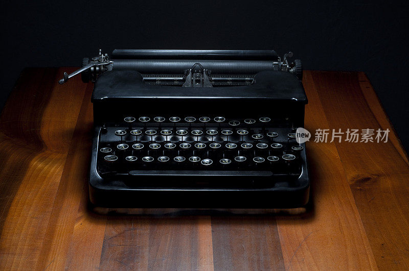 木制书桌上的老式黑色打字机