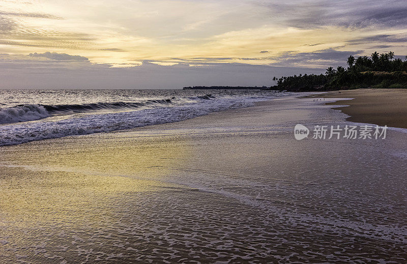 印度喀拉拉邦坎努尔Thottada海滩上的日落。
