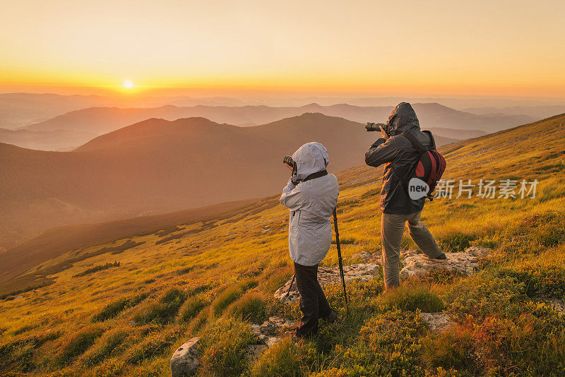 摄影师在山上拍摄日落