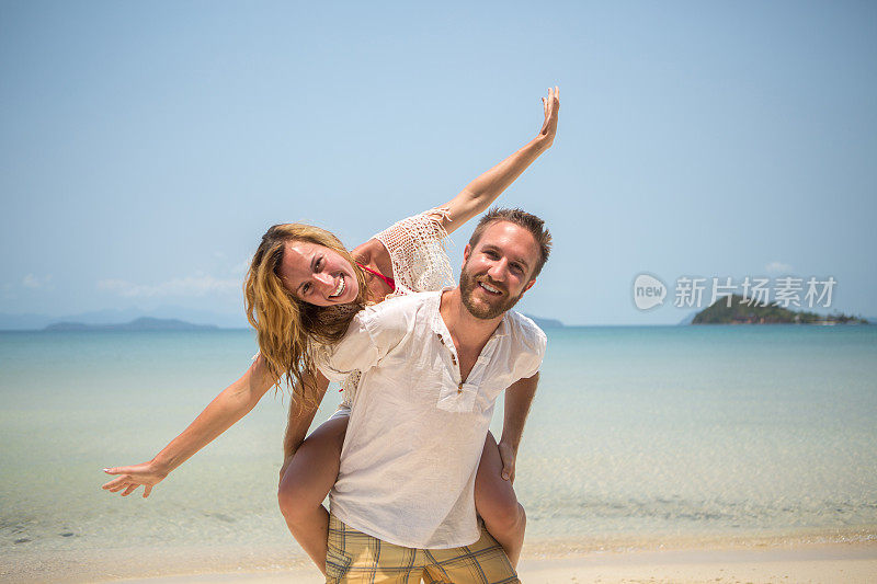 好玩的年轻夫妇在热带海滩上