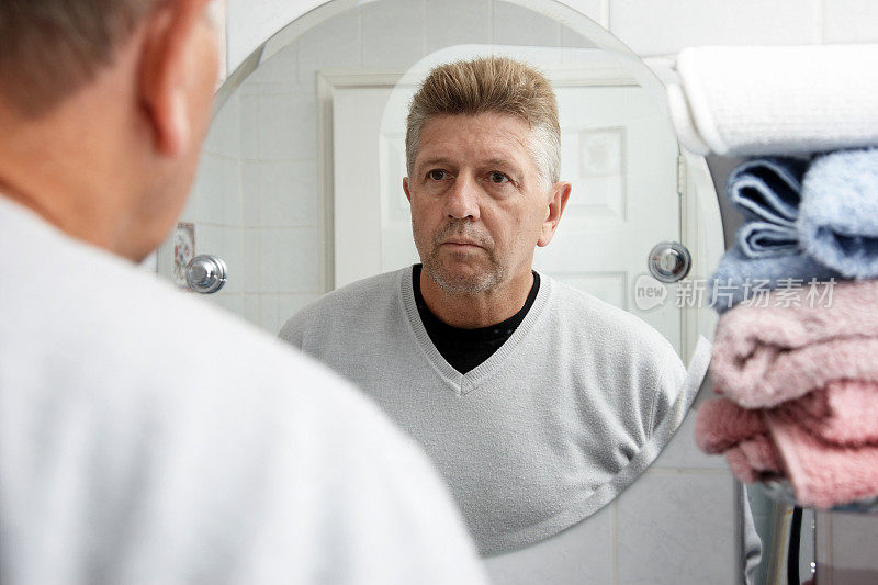 男人在浴室镜子里检查胡茬