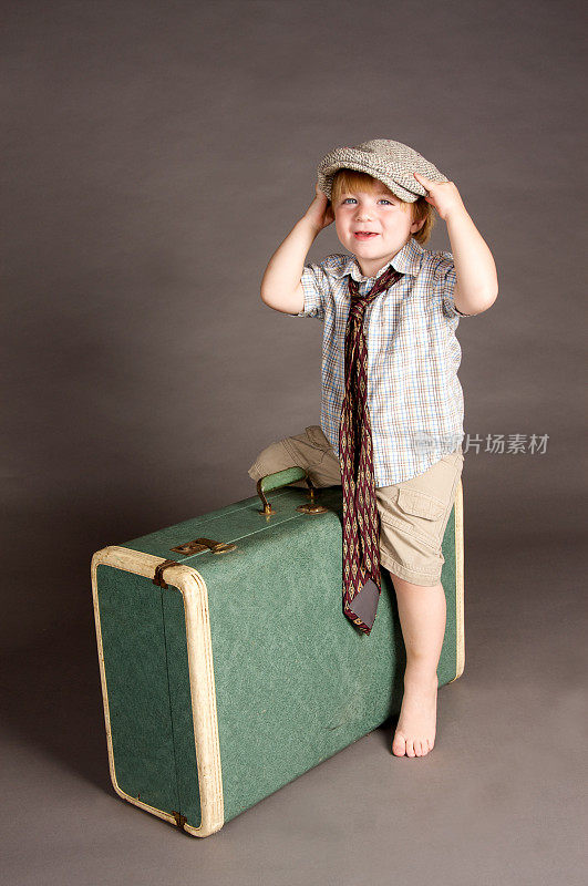 可爱的小男孩与一个古董手提箱和帽子