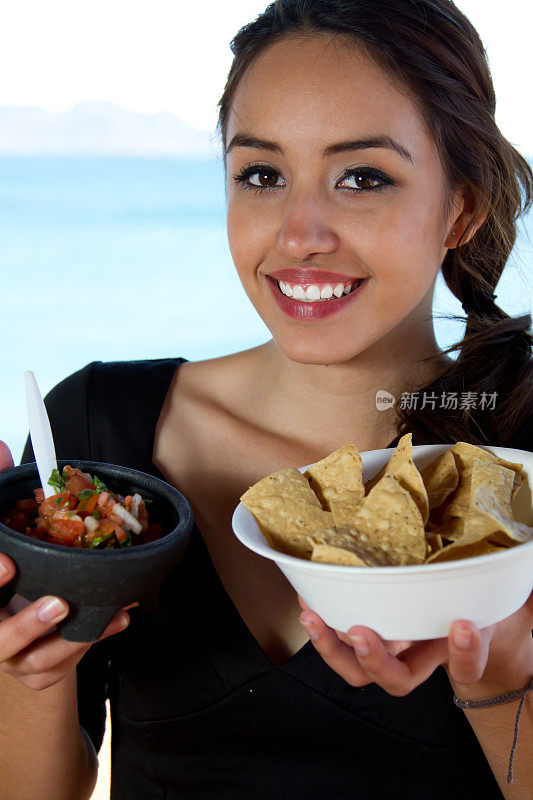 墨西哥女人提供薯条和莎莎酱