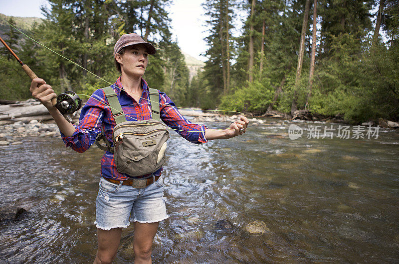 在美国西部的一条河上飞钓鳟鱼。