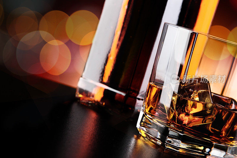 威士忌酒杯和酒瓶放在吧台上