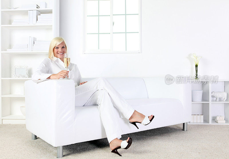优雅的女子坐在全白的房间里捧着一个