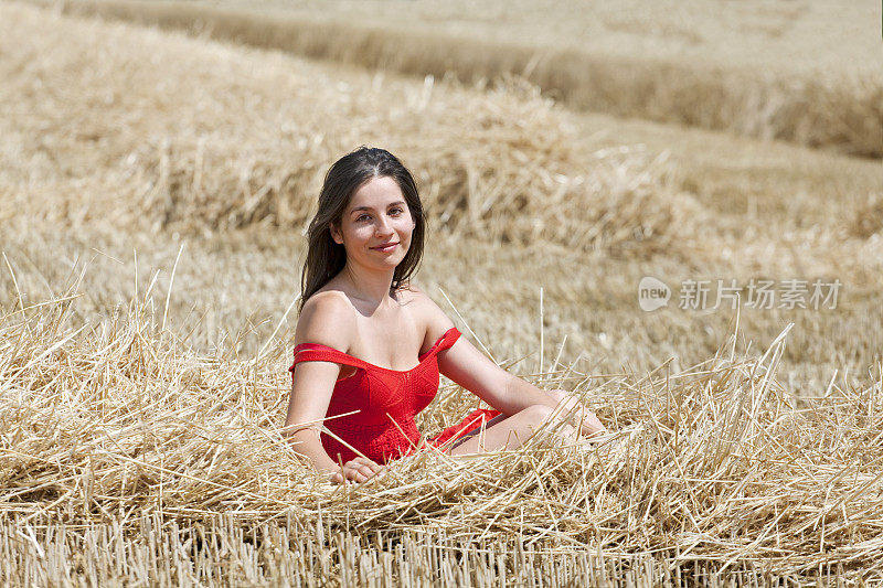 一个年轻女子在收获后的麦茬上晒太阳