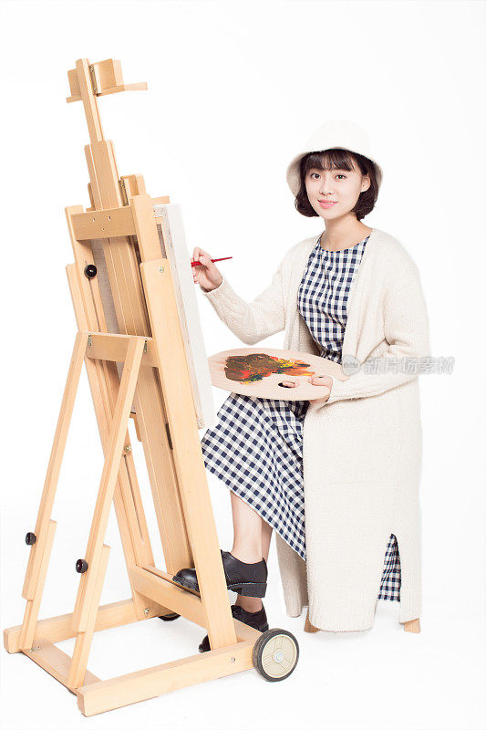 中国画家美丽的女孩，坐在写生板前，拿着调色板