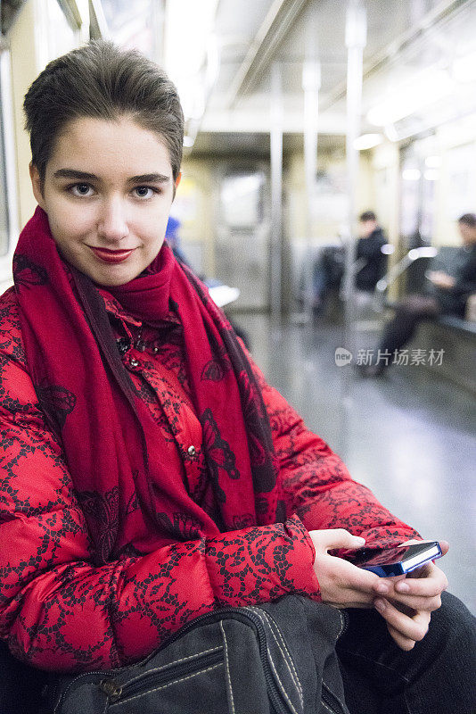 一名年轻女子在纽约地铁上使用智能手机