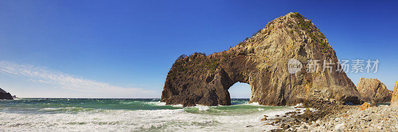 日本伊豆半岛岩石嶙峋的海岸线上的天然拱门