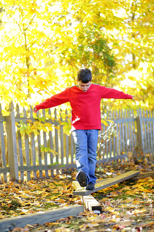 男孩在自制平衡木上向前迈了一步