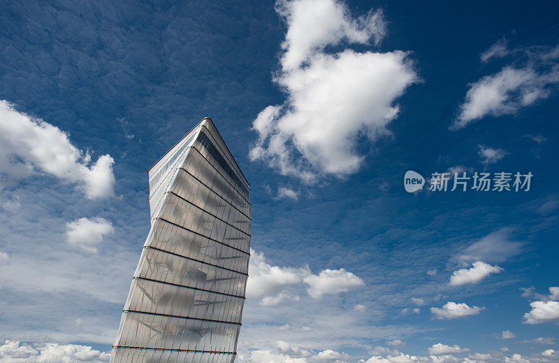 现代螺旋塔与蓝色多云的天空