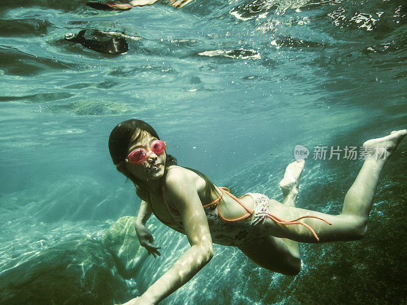 7岁女孩在清澈的河水中游泳