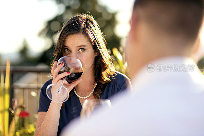 成年女性从酒杯中啜了一口