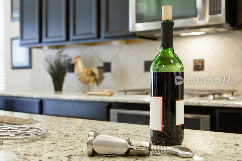 饮品:现代厨房中的红酒酒瓶和开瓶器。
