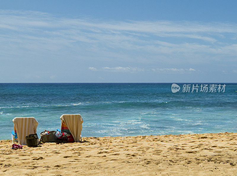 两把沙滩椅和绿松石海洋