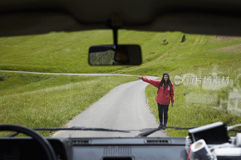 女人搭便车旅行。多山的地形。司机的观点