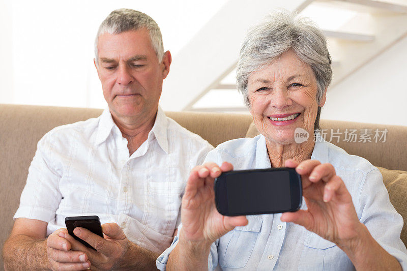 老夫妇坐在沙发上玩手机