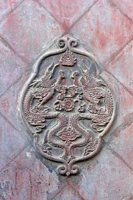 龙的造型雕塑在一座寺庙的墙上，特写照片
