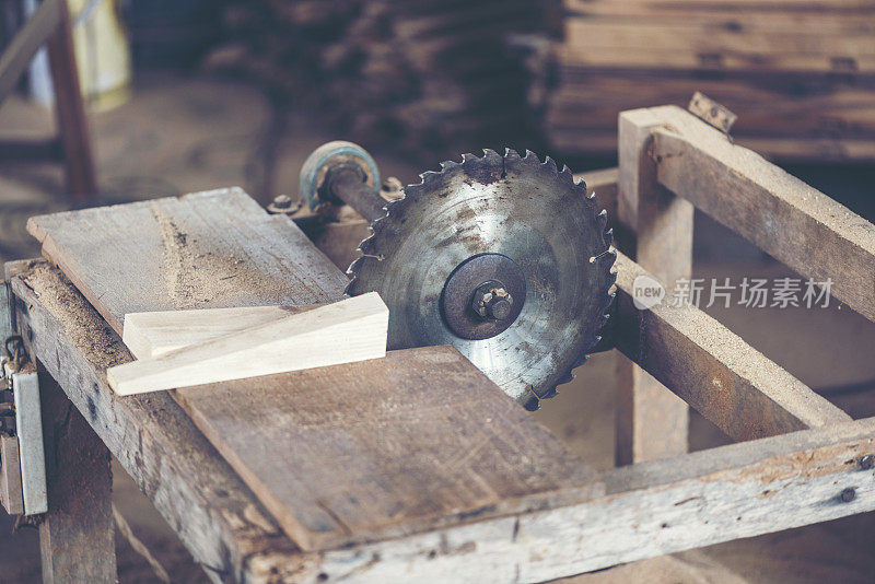 木工车间的背景图像:木工工作台与不同的工具和木材切割架，复古滤镜图像
